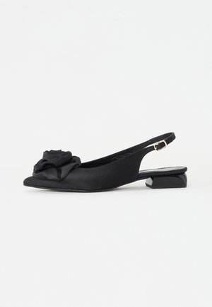 Scarpe slingback nere con un accento testurizzato a forma di rosa sulla punta, caratterizzate da un tacco basso a blocco e un materiale superiore liscio.