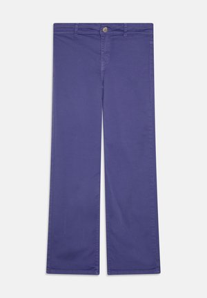 Proste spodnie o prostych nogawkach w jednolitym głębokim niebieskim kolorze z zapięciem na guziki i zamek z przodu, z pętlami na pasek oraz bocznymi kieszeniami na jednolitym tle.