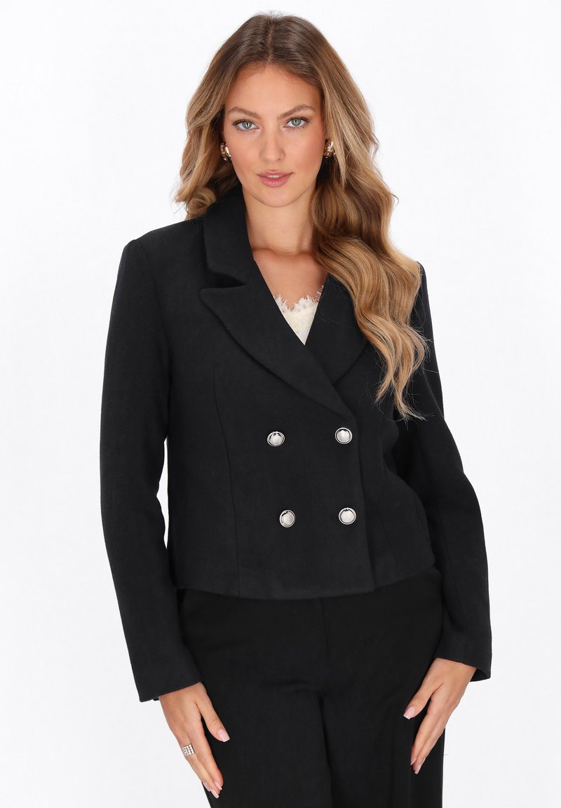 Schwarzer, doppelt gehängter Blazer mit einem Reverskragen, silbernen Knöpfen und kürzerem Schnitt. Weiche Textur, strukturierte Form.