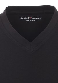 T-shirt in cotone nero con scollatura a V, dalla texture liscia. L'etichetta riporta la scritta "CASA MODA" con taglia "Media."