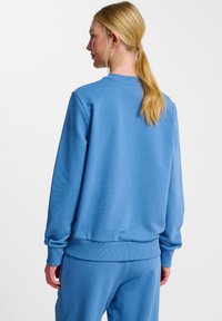 Lichtblauwe sweatshirts van zachte stof. Heeft ribbels aan de manchetten en onderkant. Beschikt over een eenvoudige ronde halslijn en een ontspannen fit.