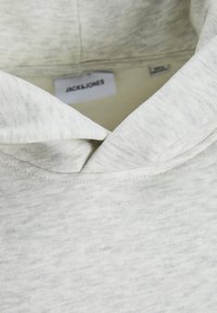 Jasnoszara bluza z kapturem o teksturowanej tkaninie, z kapturem zakrywającym i widoczną metką JACHS&JONES wewnątrz dekoltu.