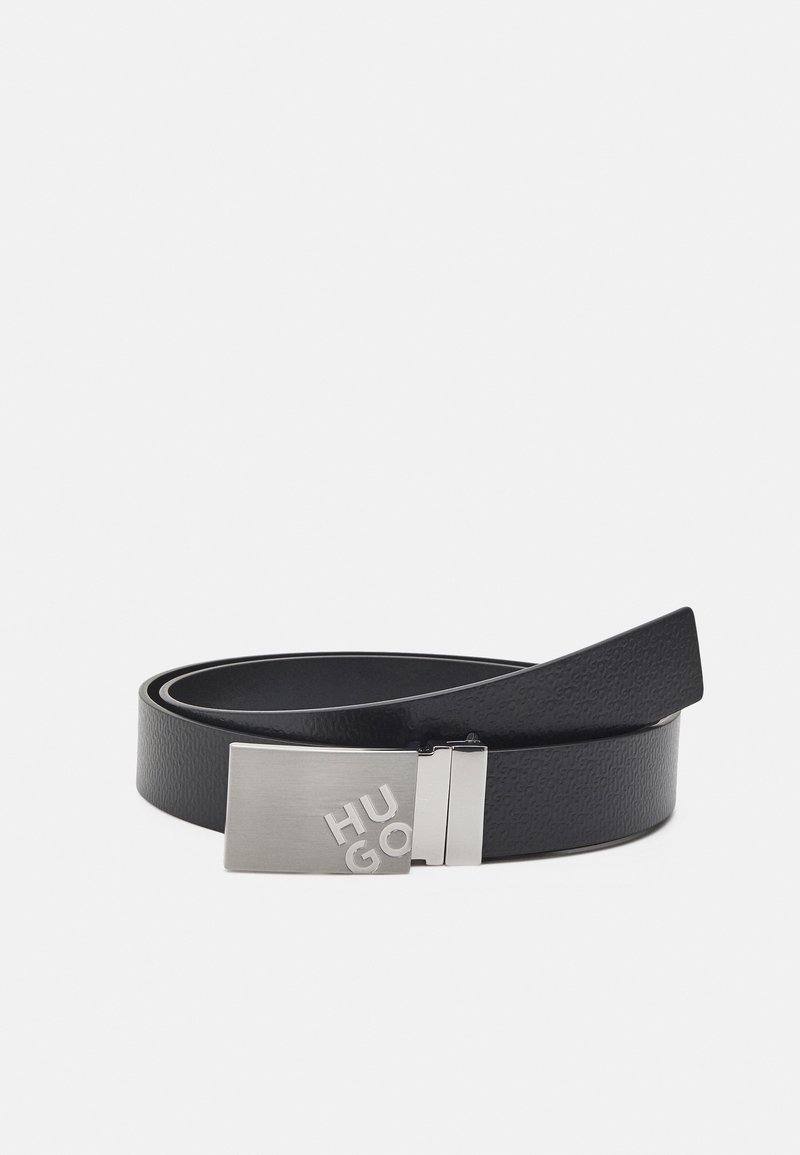 Ceinture en cuir noir avec surface texturée et boucle rectangulaire en argent gravée des lettres "HUGO".