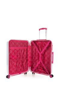 Maleta blanca de carcasa dura con acentos rosas. El interior cuenta con un forro rosa, un bolsillo con cremallera y correas elásticas cruzadas. Cuatro ruedas para mayor movilidad.