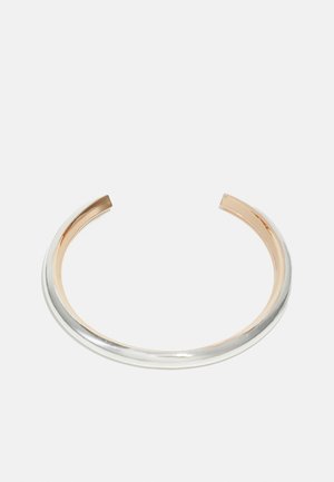 Zilveren en roségouden manchetkettinkje met een gladde metallic afwerking, met een minimalistisch ontwerp en open uiteinden voor verstelbare maat.