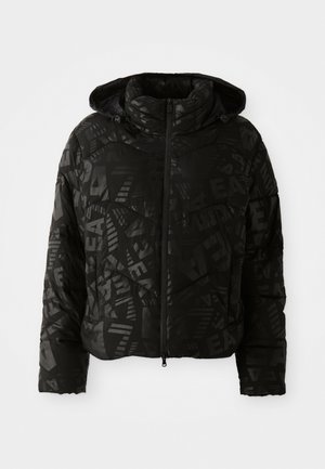 Zwarte pufferjack met capuchon, volledige ritssluiting aan de voorkant en een subtiele patroonprint met letters en geometrische vormen.