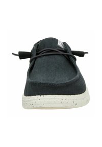Zapatillas de tela negra con punta redondeada, diseño minimalista, cordones elásticos y suela blanca salpicada.