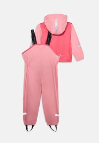 Rosa Regenjacke mit Kapuze und reflektierenden Akzenten, kombiniert mit passender Latzhose mit verstellbaren Trägern und elastischen Bündchen.