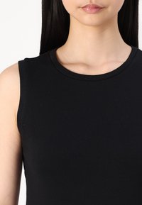 Black sleeveless top with a round neckline, made from a smooth cotton blend. Features a fitted design with clean edges.