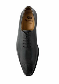 Zwarte leren dresschoenen met een spitse neus, een vetersluiting met zes oogjes en decoratieve perforaties op de neus. Gladde textuur.