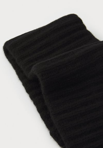 Tela de punto ribeteada negra doblada, mostrando una textura suave y un diseño grueso. Presenta un patrón uniforme y sin hardware o acentos visibles.