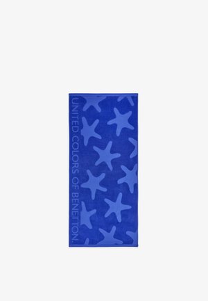 Blauwe strandhanddoek met lichtere blauwe zeesterrenpatronen en de tekst "UNITED COLORS OF BENETTON" langs de linkerrand.