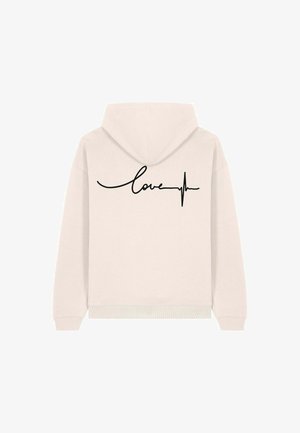 Svijetlosmeđi dukserica s kapuljačom s dizajnom za prebacivanje preko glave. Crni kurzivni tekst "ljubav" uz naglasak na EKG liniji proteže se horizontalno preko leđa.