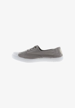 Zapatilla sin cordones de lona gris con suela de goma blanca y puntera blanca, con ojales pero sin cordones.
