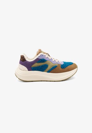 Sneaker multicolore caratterizzato da un mix di materiali blu, viola, marrone e verde, con una tomaia testurizzata, una fodera soffice e una suola bianca spessa.