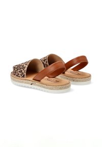 Sandalias de estampado de leopardo con correas de cuero marrón, plantillas de yute trenzado y suelas de goma blanca. Diseño de parte trasera abierta para facilitar el uso.