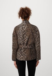 Leopardmönstrad jacka med avslappnad passform, midjebälte, tillverkad i lättviktig tyg. Har en krage och långa ärmar, visas från baksidan.
