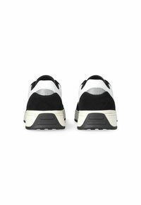 Sneaker in bianco e nero con materiali in suede e pelle, forma arrotondata, suola in gomma testurizzata e logo embossato sul tallone.