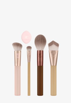 Cinq pinceaux de maquillage et une éponge de maquillage rose sont disposés sur un fond blanc, chaque pinceau ayant des formes et des couleurs de manche différentes.