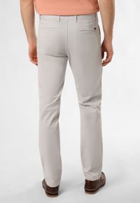 Chinos gris clair avec une coupe droite, deux poches arrière et une texture lisse, associés à des chaussures en cuir marron.