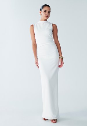 Robe maxi blanche sans manches en tissu lisse et extensible. Elle présente un col haut et une silhouette ajustée, avec un léger éclat.