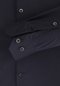 Navyblauwe longsleeve shirt van gladde stof, met knoopsluitingen op de manchetten en de voorkant, gedetailleerde stiksels en een getailleerd ontwerp.
