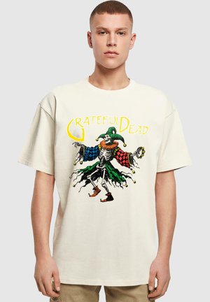 Cream cotton t-shirt featuring a colorful jester skeleton graphic by Grateful Dead. The shirt has loose sleeves and a relaxed fit.