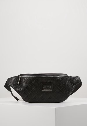 Zwarte Guess Los Angeles heuptas met geperforeerd logopatroon, ritssluiting en verstelbare band, tentoongesteld op een wit voetstuk.