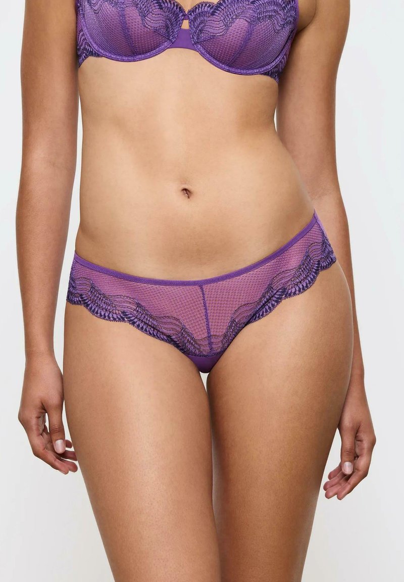 Fioletowy zestaw koronkowej bielizny składający się z biustonosza typu balconette i pasujących majtek, z przezroczystym siateczkowym wzorem i falbaniastymi krawędziami.