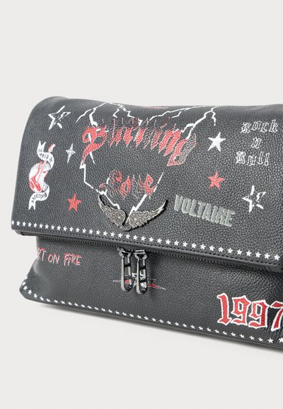 Sort faux læder taske med røde og hvide grafiske tryk, lynlåslukning og vingehardwaredekoration med tekst og rockmotiver.