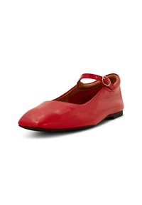 Zapato plano de charol rojo con punta afilada y una delgada correa en el tobillo asegurada por una hebilla de plata. Presenta una suela baja de color negro.