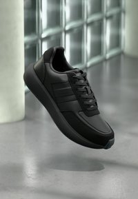 Μαύρα συνθετικά αθλητικά παπούτσια με λεία δερματική υφή, σχέδιο με κορδόνια και διακριτικά λογότυπα στο πλάι. Σχεδιασμένη από καουτσούκ σόλα για άνεση.