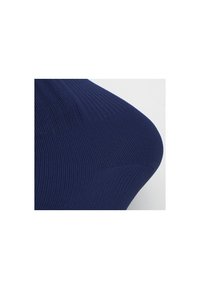 Primer plano de tela de punto acanalado azul marino moldeada sobre una superficie curva, destacando la textura y los detalles de costura.