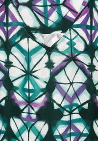 Top a scollo a V realizzato in tessuto con un motivo geometrico in teal, viola e bianco, con una finitura testurizzata e dettagli in nero.