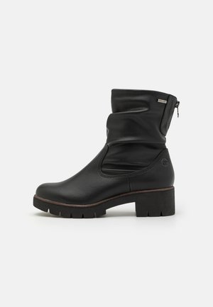 Bottes noires en cuir, à cheville, au design gâté, avec fermeture éclair latérale, talon carré, tige texturée et semelle en caoutchouc avec motif de traction.