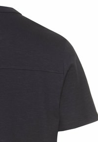 Donkergrijze polo met korte mouwen en een gladde textuur, voorzien van een naaddetail over de rug en een klassieke kraag.
