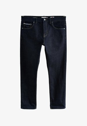 Mørkeblå denim jeans med fem lommer, knaplukning og kontrastsyninger, lagt fladt mod en hvid baggrund.