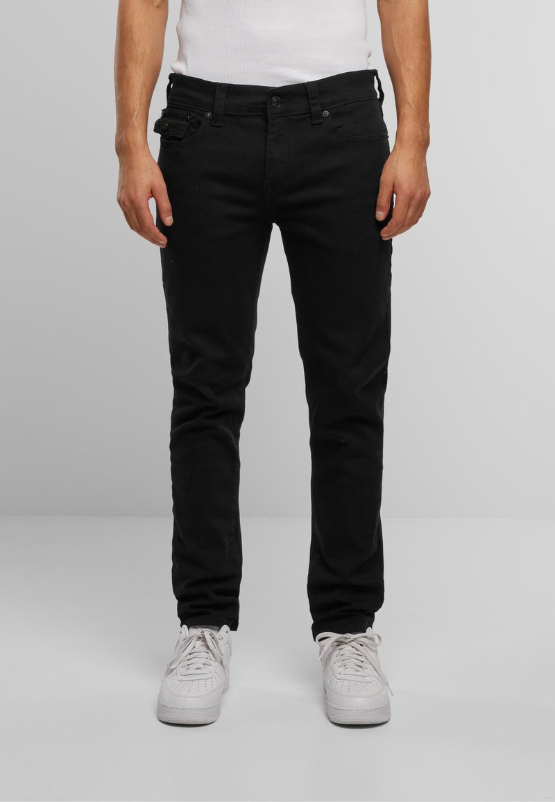 Jeans negre din denim cu croi slim, cinci buzunare, detalii subtile de cusătură și talie medie. Asortați cu adidași albi.