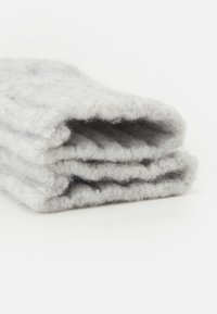 Grå filt teppe, brettet. Myk tekstur med et tykt, varmt design, som har et subtilt, glatt utseende med en lys glans.