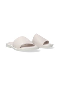 Lichtroze schuifsandalen van zacht leer met brede, gebogen banden en een flexibele witte zool. Gladde textuur, minimalistisch ontwerp.