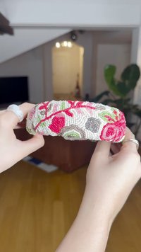 Koristeellinen helmihiusnauha, jossa on kukkakuosi punaisena, vihreänä ja valkoisena. Pintakuvio on sileä, ja siinä on monimutkaisia helmikuvioita ja yksityiskohtia.