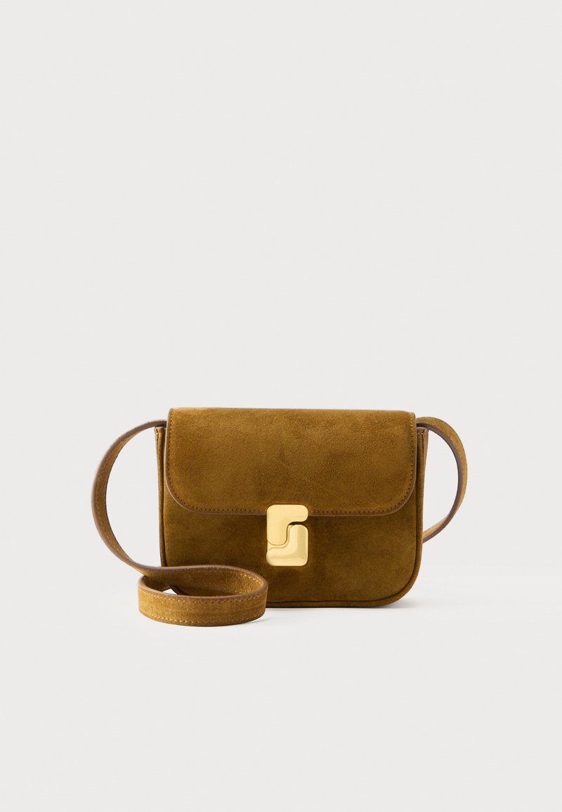 Καφέ σουέτ τσάντα ώμου με στρογγυλεμένες άκρες και χρυσό ορθογώνιο κούμπωμα, ιμάντας χαλαρά τυλιγμένος μπροστά σε λευκό φόντο.