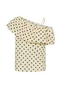 Blouse crème à une épaule avec des pois noirs et un grand volant traversant l'encolure et l'épaule.
