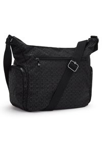 Black fabric shoulder bag with geometric pattern, adjustable strap, multiple zip pockets, and a soft texture. Compact and versatile design.