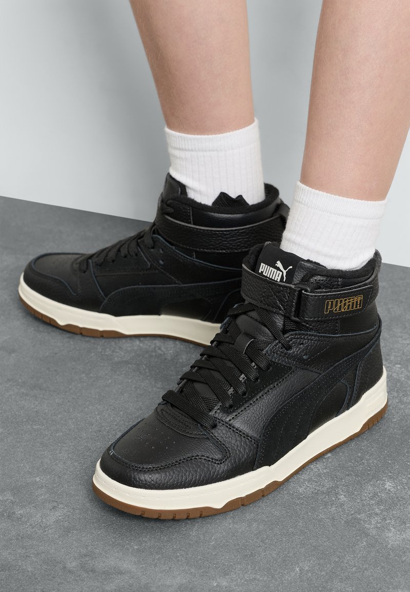 Czarne wysokie sneakersy z cholewą skórzaną i syntetyczną, z białą podeszwą pośrednią i gumową podeszwą zewnętrzną. Teksturowane akcenty i detal z logo.