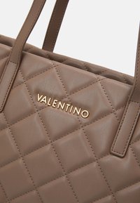 Hnědá prošívaná kožená kabelka s zlatým logem "VALENTINO". Vyznačuje se robustními popruhy a texturovaným povrchem s diamantovými vzory.