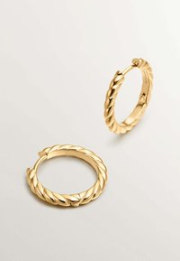 Pendientes de aro de oro con un diseño retorcido, que presentan un acabado metálico brillante y un cierre de gancho. Textura suave y forma circular.