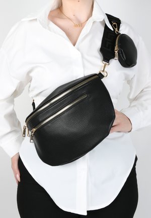 Marsupio in pelle nera con superficie testurizzata, due scomparti con cerniera, hardware dorato e una piccola borsa staccabile sulla tracolla.