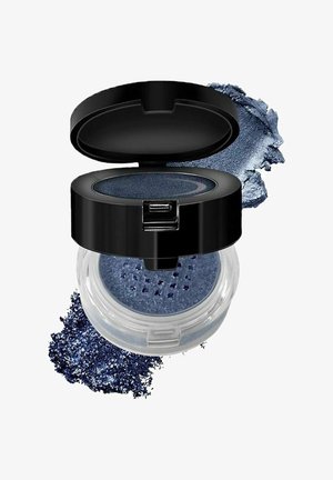 Laikku sininen irtopigmentti kirkkaassa pyöreässä astiassa, jossa on musta, saranoidulla kannella. Karkea jauhe valuu sivulle, syventäen värin rikkautta.