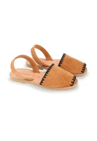 Chaussures slingback en suede tan avec des coutures zigzag noires le long des bords et une semelle en caoutchouc plate. Texture lisse et design à talon ouvert.